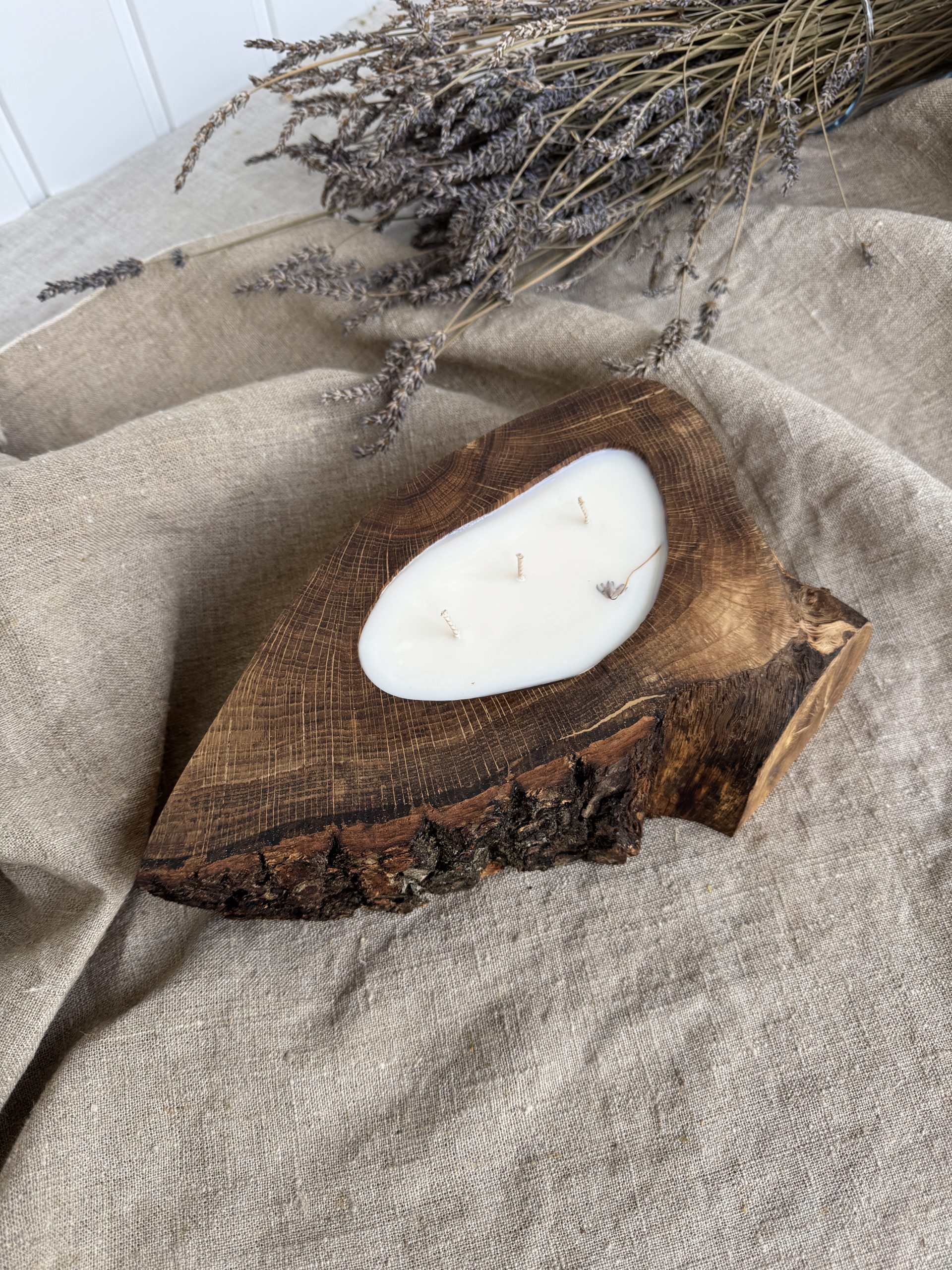 Handmade sandalwood soy candle in rustic oak wood with bark texture