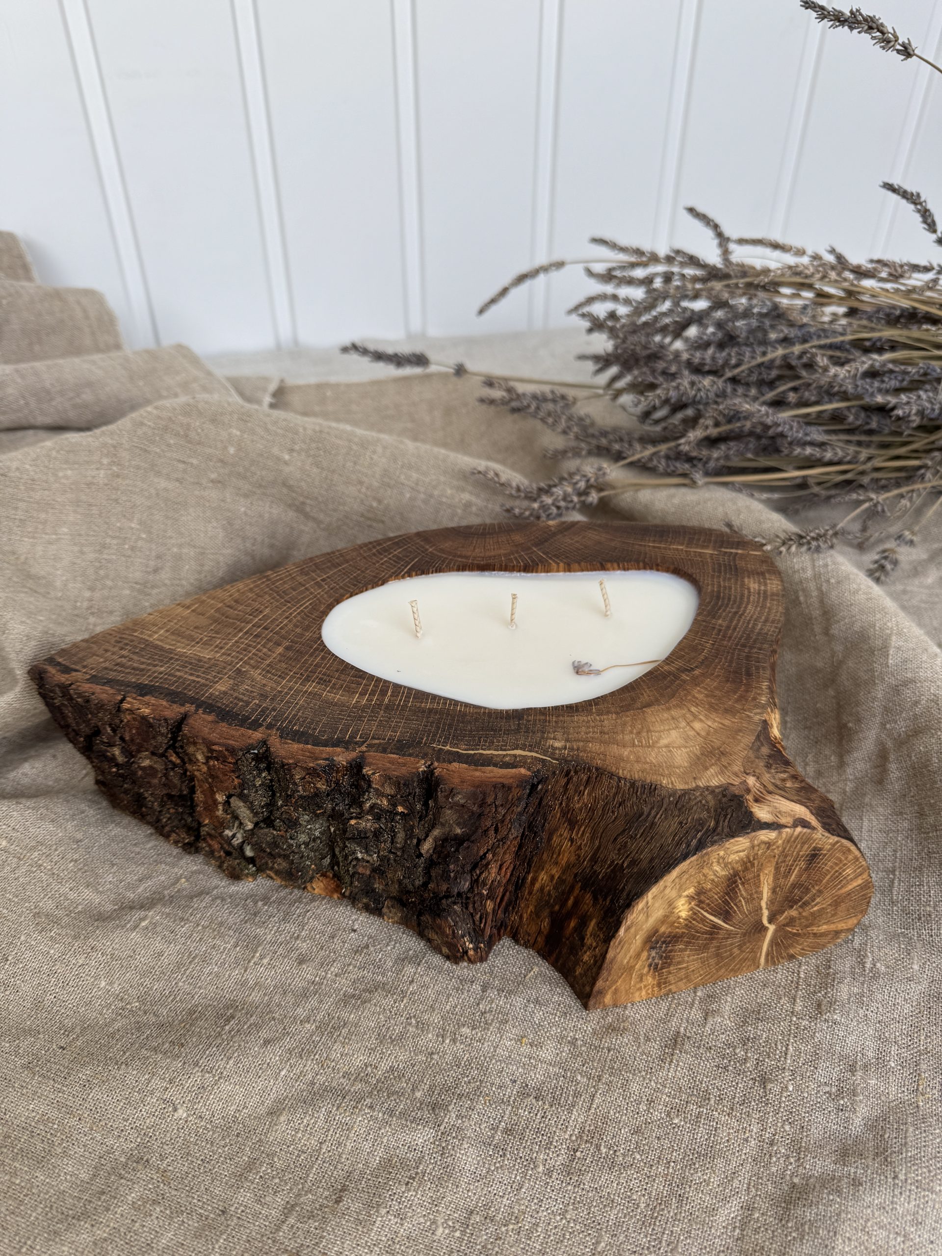 Handmade sandalwood soy candle in rustic oak wood with bark texture