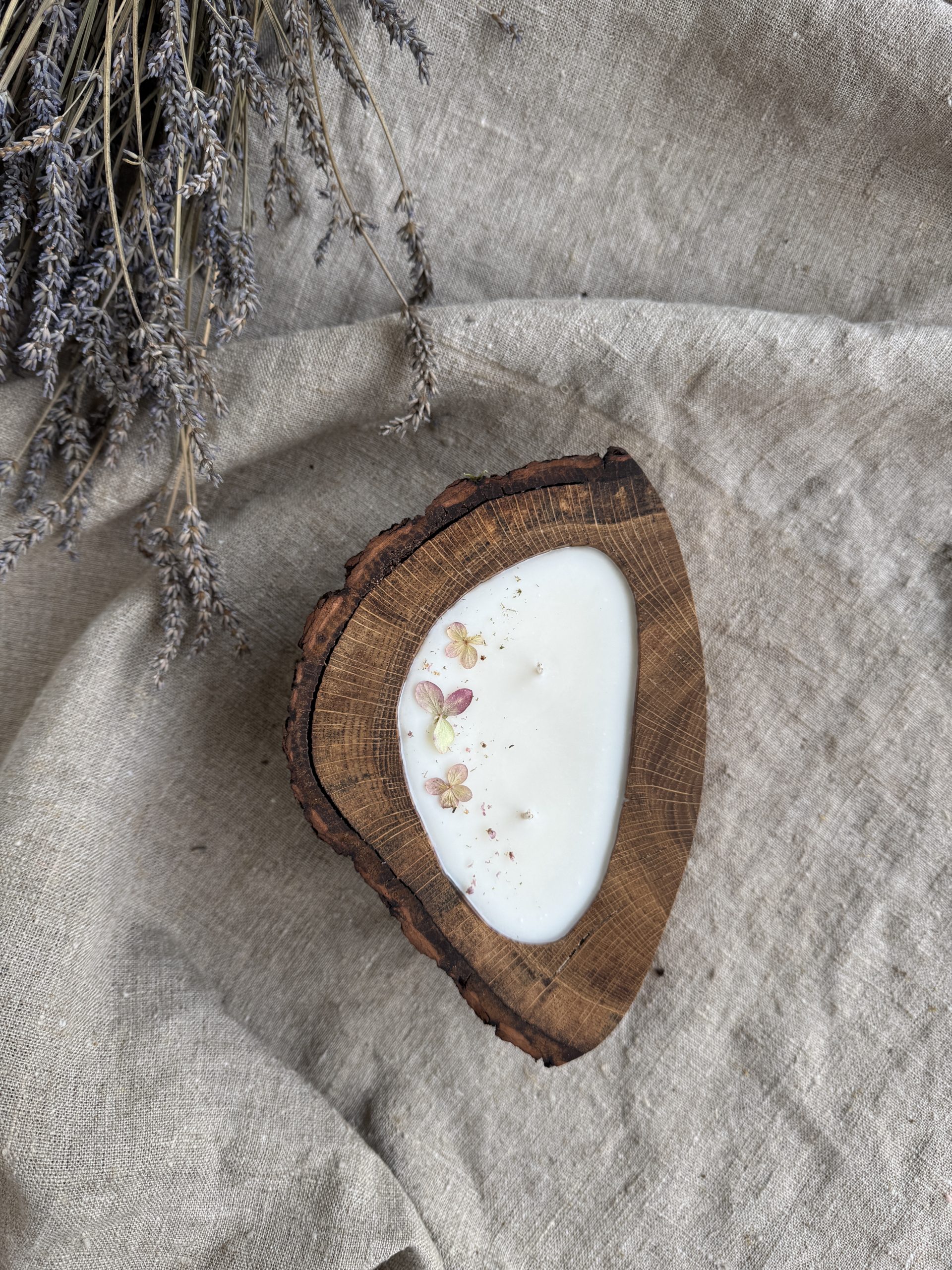 Handmade melon soy candle in rustic oak wood with bark texture