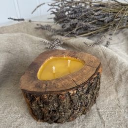 Handmade natural beeswax candle in rustic ash wood vessel with preserved bark texture