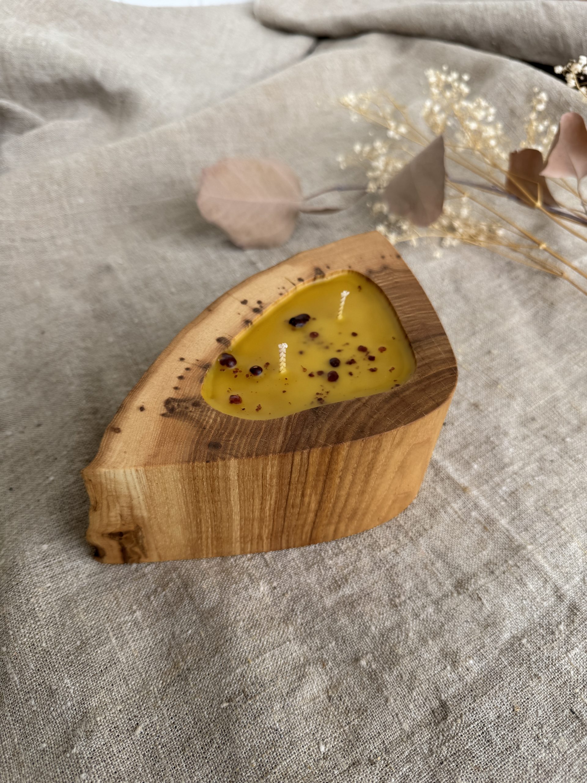 Handmade beeswax candle with propolis in natural ash wood vessel with two cotton wicks