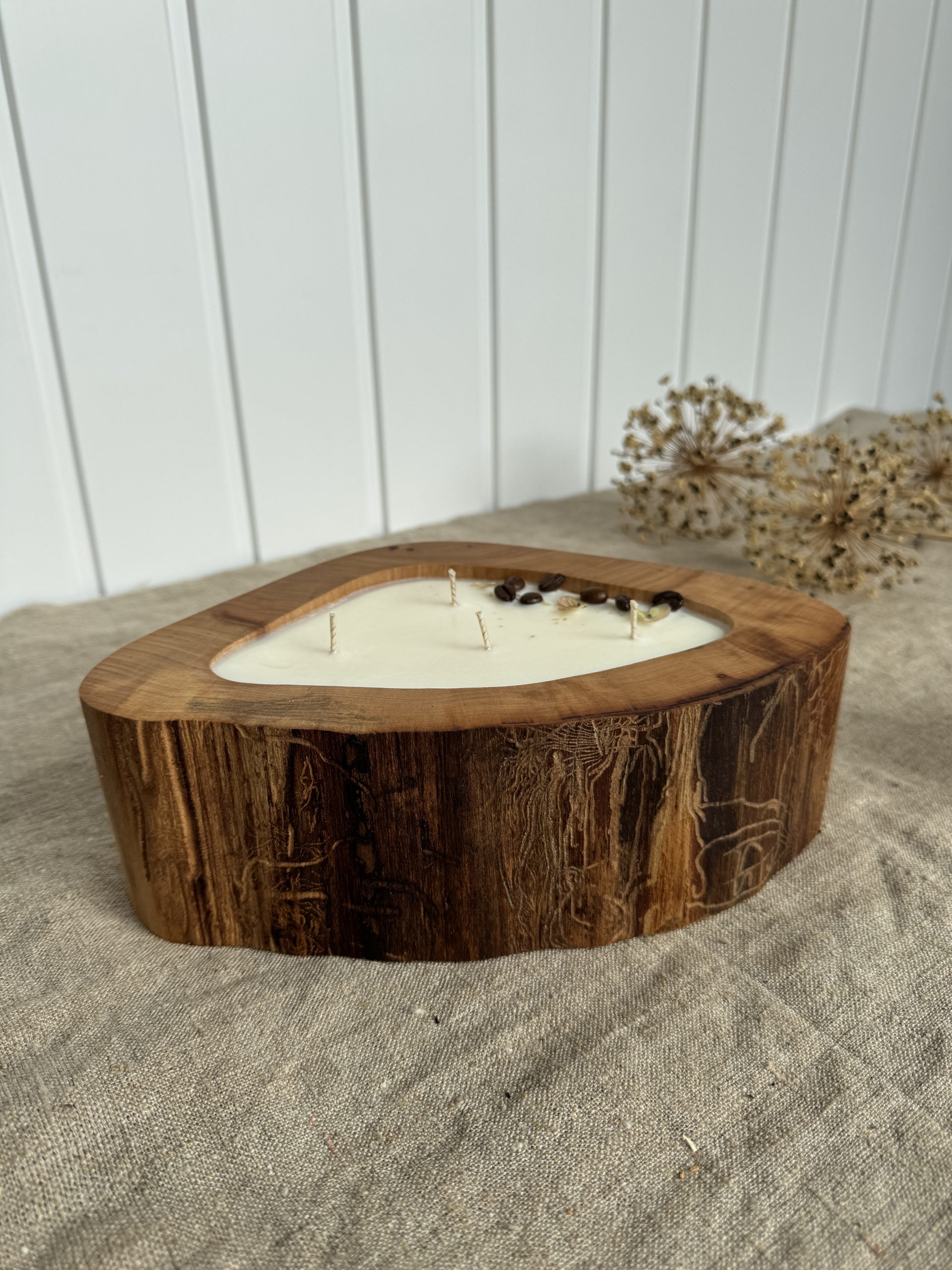 Handmade coffee scented candle in a natural elm wood bowl decorated with coffee beans and dried flowers