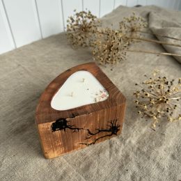 Handmade alder wood candle with vanilla fragrance and decorative burnt wood patterns on the sides