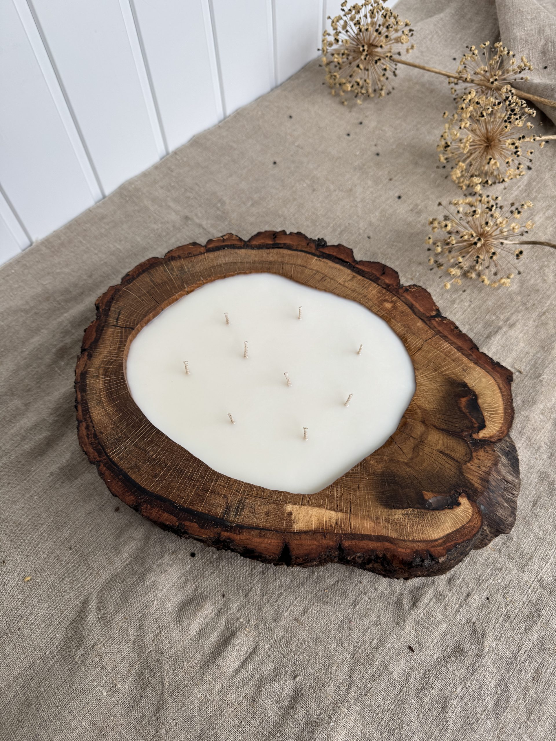 Large handmade oak wood candle with nine cotton wicks in a natural oak wood vessel with bark edge